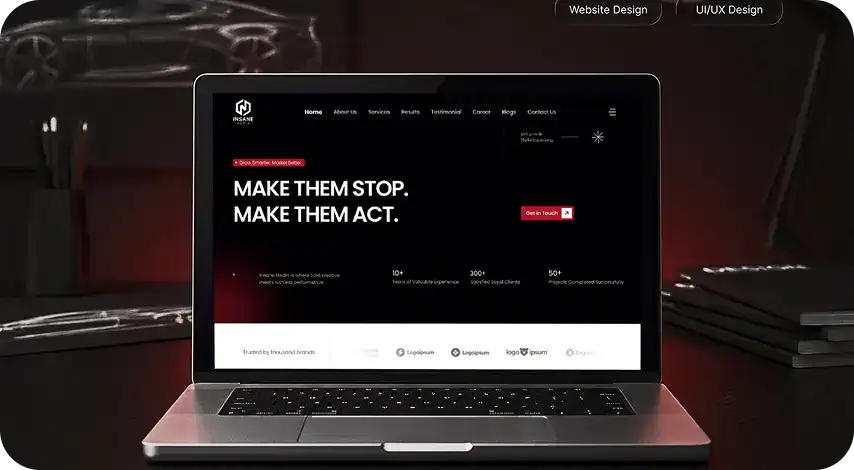 Laptop displaying a website with a dark theme and bold text for branding.